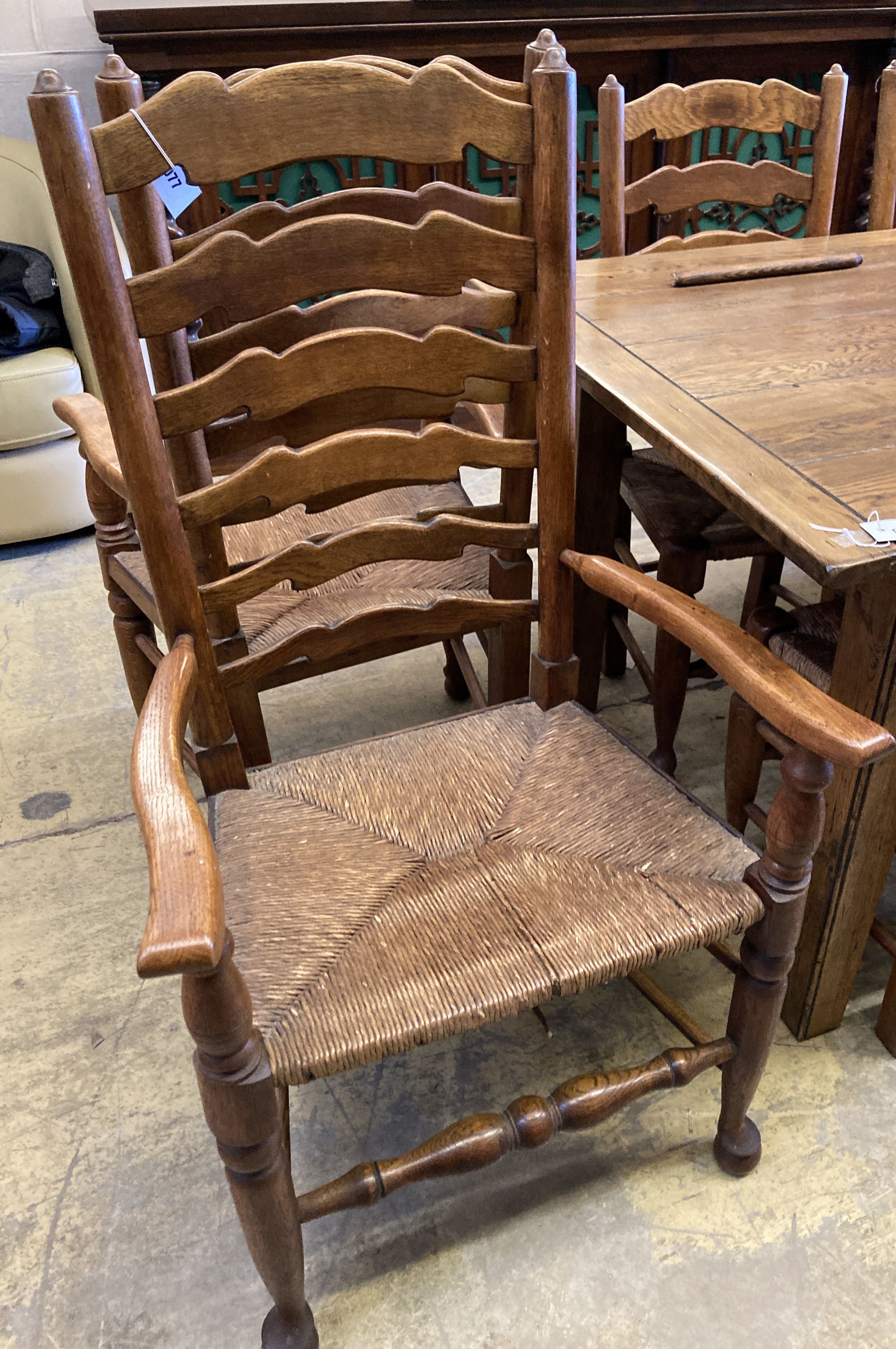 A set of six ladderback dining chairs with rush seats, two having arms